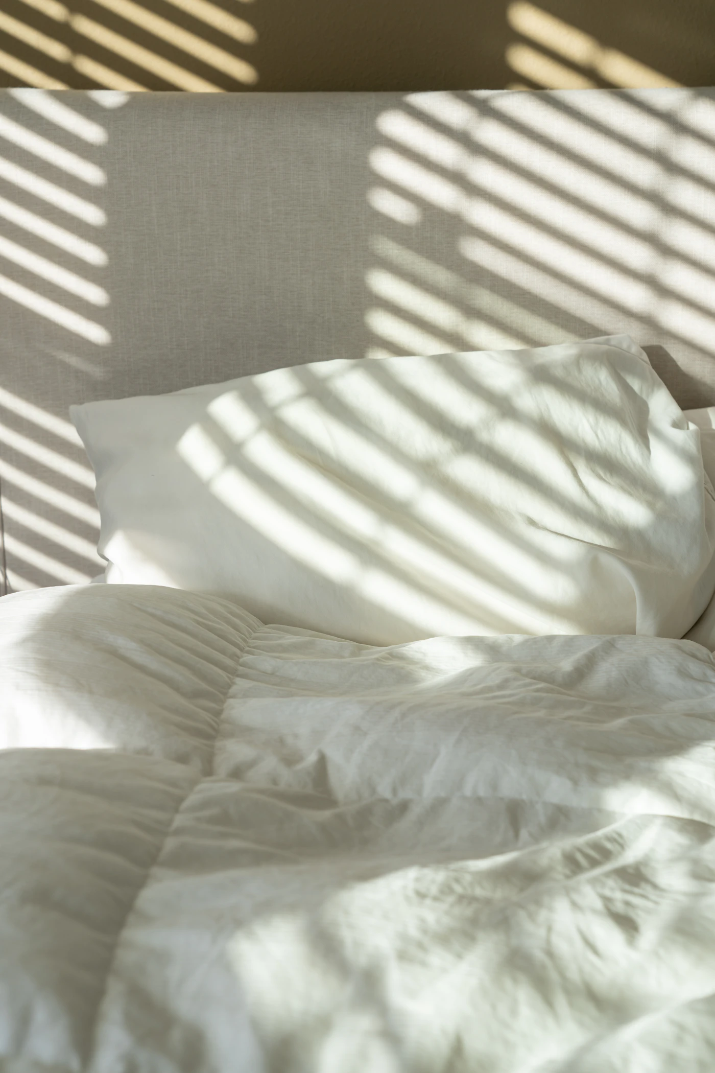 Airbnb bedroom made up with crisp white linens during a same day turnover clean before guest check in