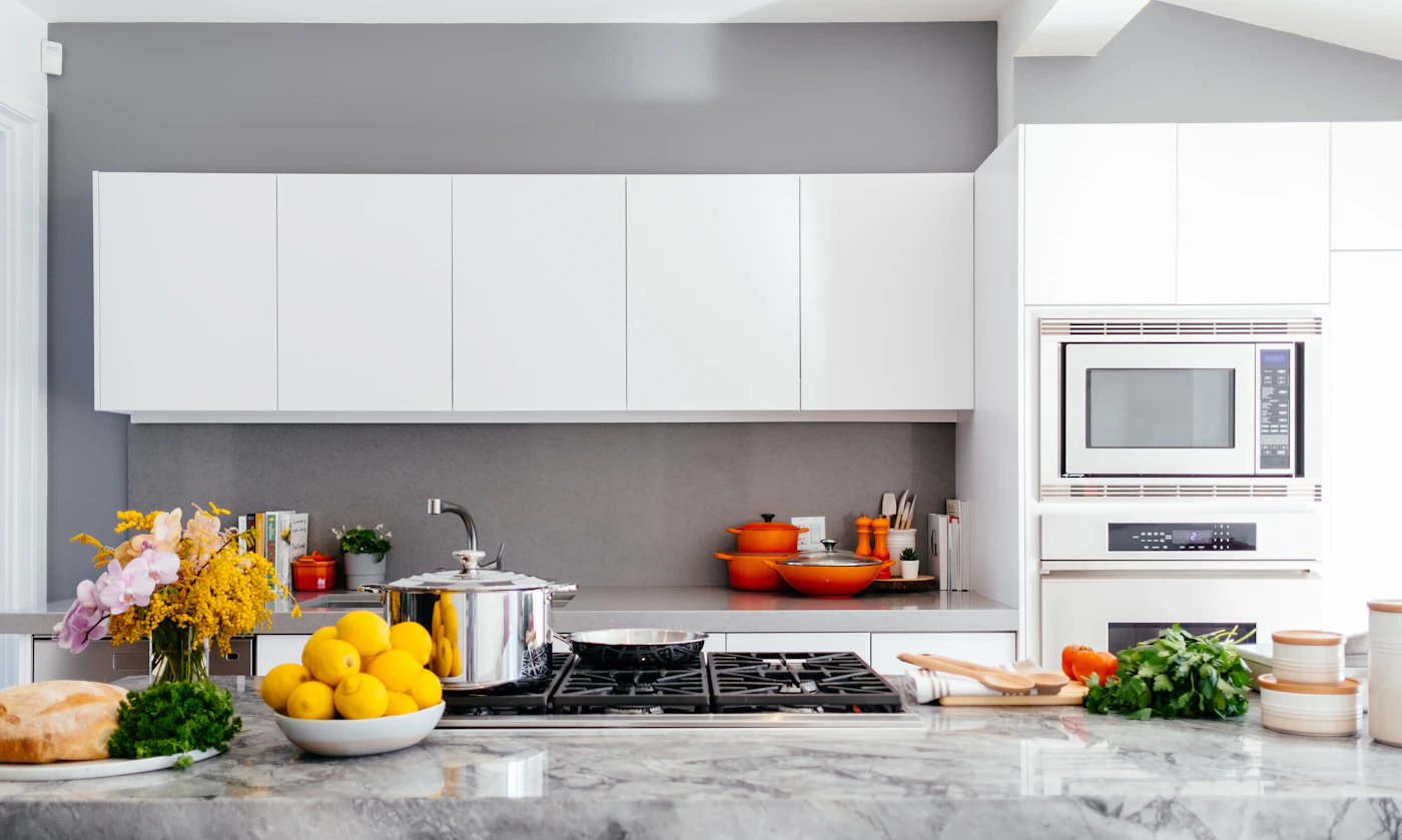Deep cleaned modern kitchen with a polished marble island, spotless cabinets and stainless steel appliances