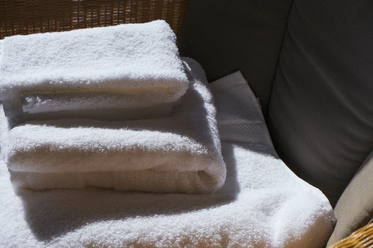 Stack of freshly laundered and folded white towels left by a Hypermaids housekeeper