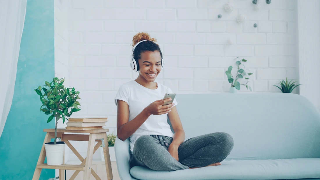Woman relaxing on the sofa in her freshly cleaned Toronto home while the cleaning team finishes up